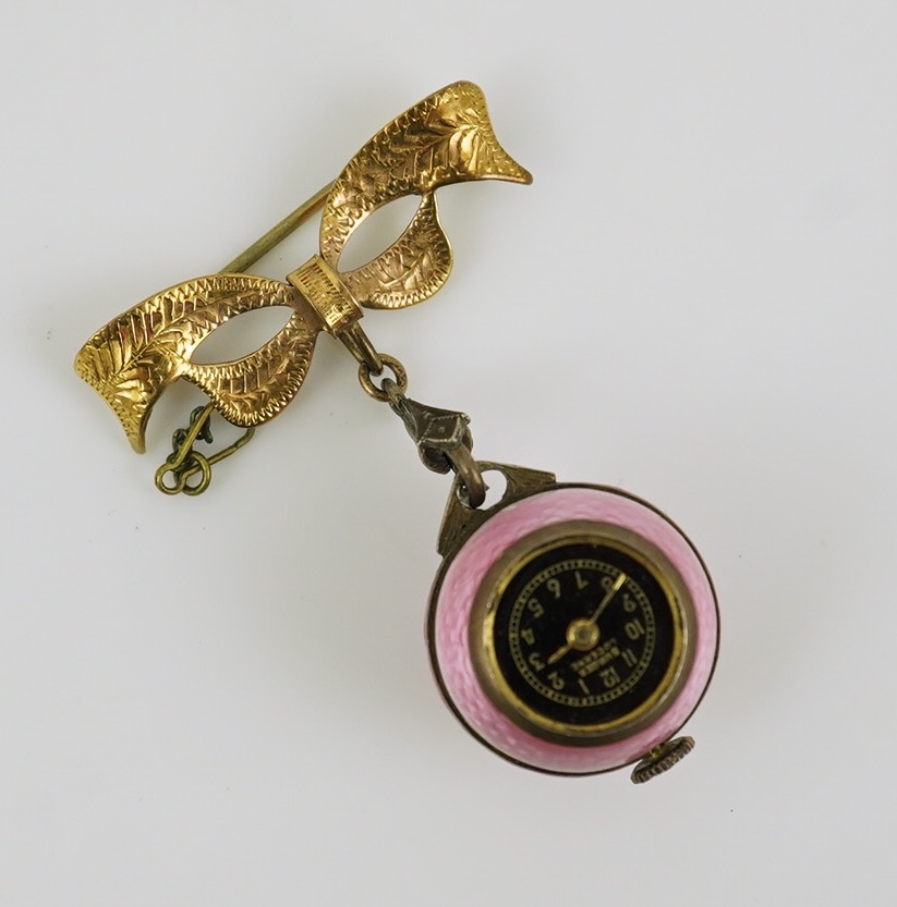 An early to mid 20th century silver and pink guilloche enamel Burger manual wind globe lapel watch, on a later 9ct gold ribbon bow suspension brooch